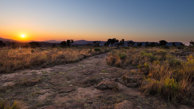 Sentiero per pedoni concreto che conduce al punto di vista di Blyde River Canyon, destinazione famosa di viaggio nel Sudafrica. Luce scenica di tramonto sulle creste della montagna.