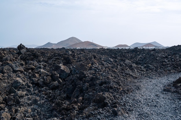 Sentiero tra lava con vista sul vulcano Caldera Blanca Timanfaya Isole Canarie Lanzarote Spagna