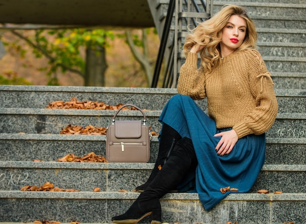 Sentirsi alla moda. capelli ricci donna autunno all'aperto. studente stile casual. stagione autunnale. bellezza femminile. Modella. ragazza in gonna ondulata e maglione. Tendenza pieghettata. scale capelli lunghi biondi della ragazza.