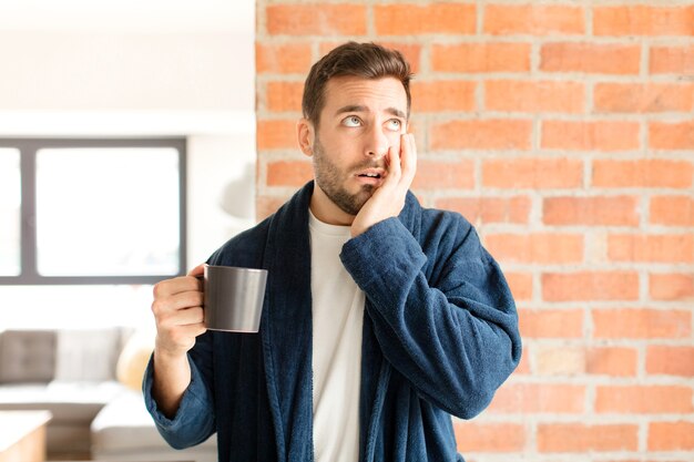 sentirsi annoiato, frustrato e assonnato dopo un compito noioso, noioso e noioso, tenendo il viso con la mano