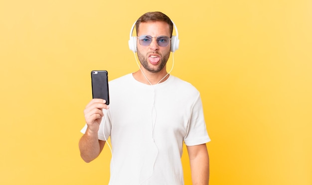 Sentirsi disgustato e irritato e con la lingua fuori, ascoltare musica con le cuffie e uno smartphone