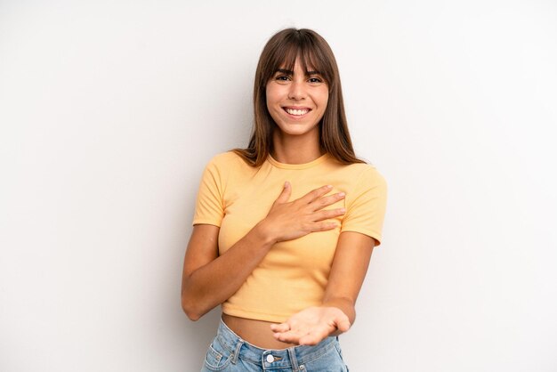 Sentirsi felici e innamorati sorridendo con una mano vicino al cuore e l'altra tesa davanti