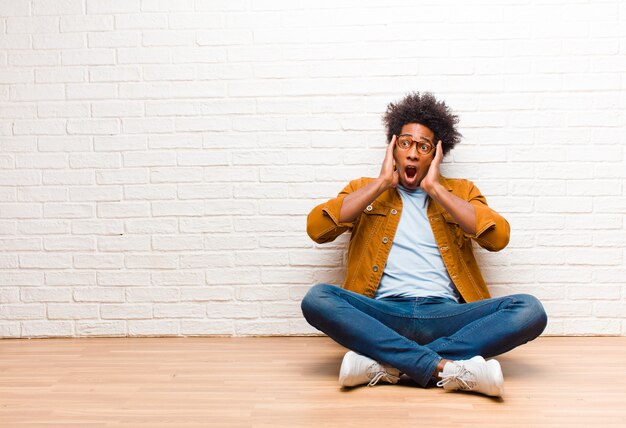 sentirsi felici, eccitati e sorpresi, guardando di lato con entrambe le mani sul viso