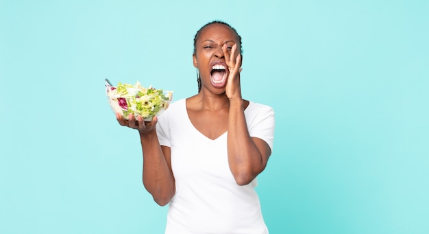 sentirsi felici, gridare con le mani vicino alla bocca e tenere in mano un'insalata