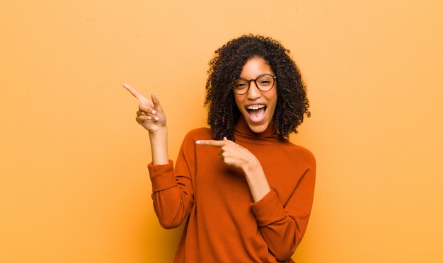 sentirsi gioiosi e sorpresi, sorridendo con un'espressione scioccata e indicando il lato