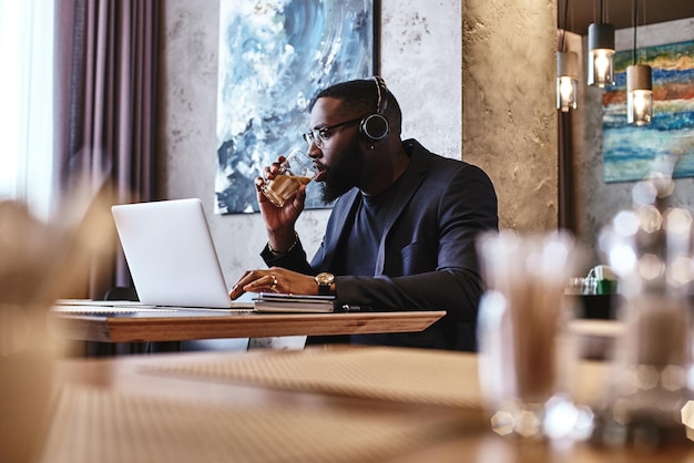 Senza lavoro niente prospera uomo d'affari afroamericano sta lavorando usando il suo laptop mentre