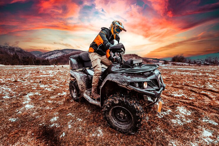 Seorang pria mengendarai ATV dalam lumpur yang melayang mengendarai quad ATV dalam lumpur dan salju