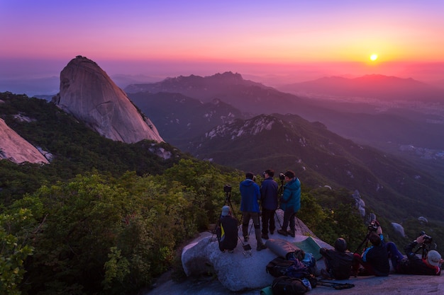 SEOUL, COREA - 28 giugno 2015: Il fotografo sta scattando una foto dell'alba al mattino sulle montagne di Bukhansan, Seoul, Corea del Sud.