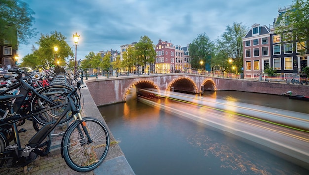 Serata ad Amsterdam Viste panoramiche delle famose vecchie case biciclette ponte e canale nel centro storico Lunga esposizione Amsterdam Olanda Paesi Bassi Europa