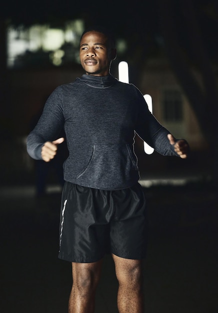 Serata di fitness o uomo di colore pronto per la corsa, allenamento cardio o allenamento in ritardo in una città buia in Nigeria Inizia la mentalità o un atleta sano che pensa alla missione o alla visione degli obiettivi sportivi