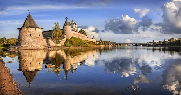 Serata estiva sul fiume vicino al Cremlino di Pskov e grandi nuvole nel cielo blu