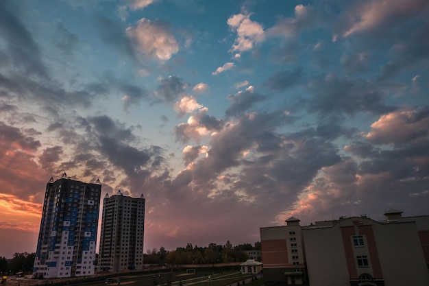 Serata soffici nuvole ondulate ricci di un fantastico tramonto sullo sfondo di condomini a più piani
