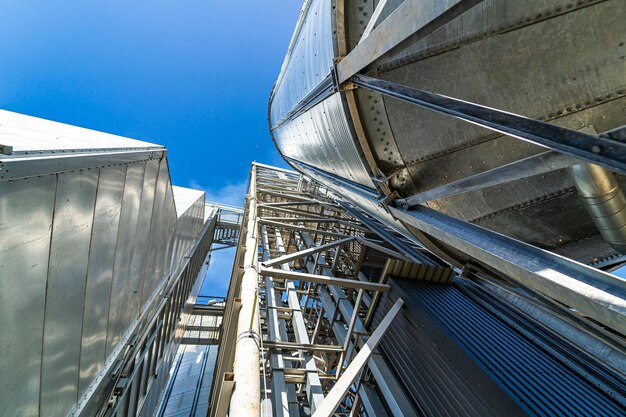 Serbatoi e silos agricoli di stoccaggio dell'elevatore del grano. Esterno dell'edificio della struttura di carico. Vista dal basso.