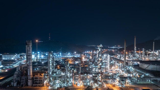 Serbatoio di stoccaggio dell'industria chimica e raffineria di petrolio in uno stabilimento industriale di notte durante l'illuminazione Zona dell'industria petrolchimica della produzione di combustibili ed energia