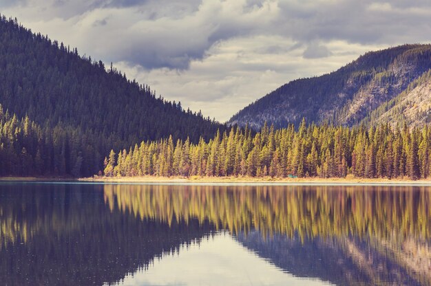 Serena scena sul lago di montagna in Canada con il riflesso delle rocce nell'acqua calma.