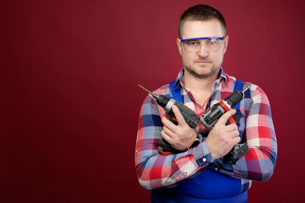 Serio riparatore caucasico con occhiali di protezione con strumenti per la lavorazione del legno ritratto di falegname