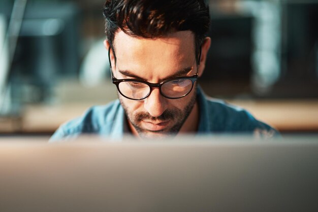 Serious man face and glasses at computer in office for planning software update online research and data analysis Focused developer desktop and internet connection for business website or coding