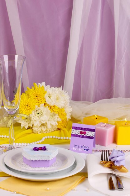 Serve favoloso tavolo da matrimonio in colore viola e giallo su sfondo di tessuto bianco e viola