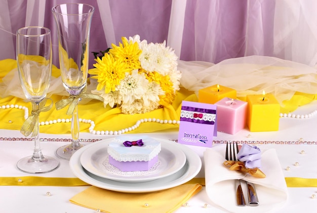 Serve favoloso tavolo da matrimonio in colore viola e giallo su sfondo di tessuto bianco e viola