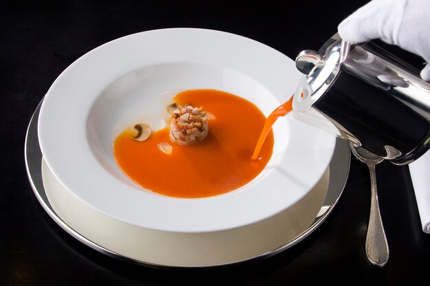 Serve zuppa di pomodoro in un ristorante gourmet.