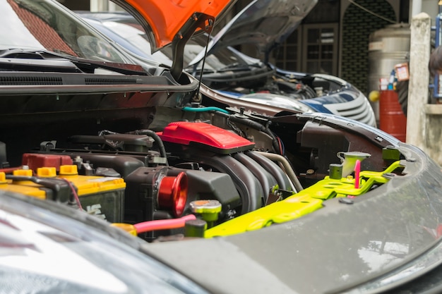 Serviceman che controlla motore in un&#39;automobile al garage