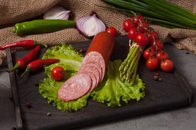 Servilat affumicato su tavola di legno decorato con verdure fresche