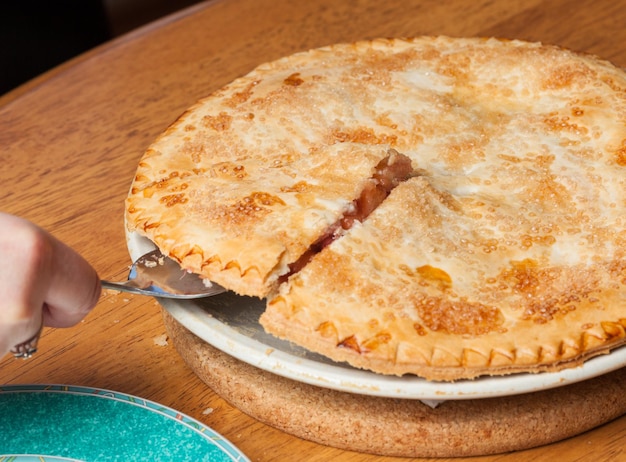 Servita la torta di mele e fragole fatta in casa