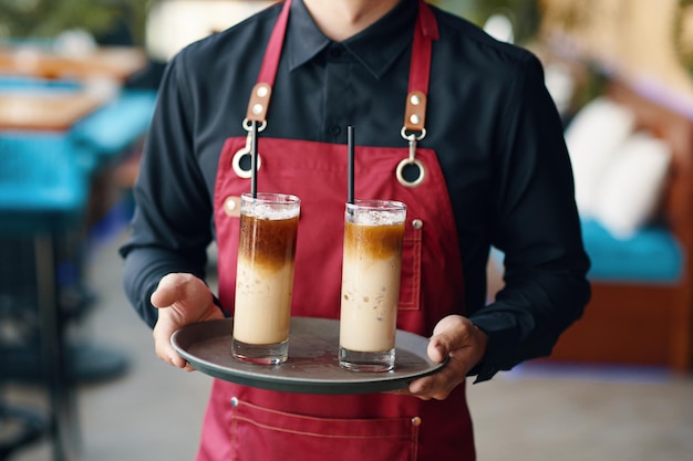 Servitore con un vassoio di caffè ghiacciato