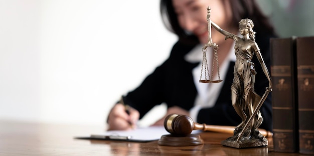 Servizi legali consulenza legale concetto di giustizia e immobili donna d'affari e avvocato che lavorano con statua in ottone su scrivania di legno in ufficio