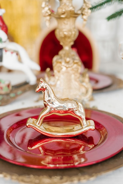Servizio di cena di Natale festoso Cavallo ricordo d'oro su un piatto da pranzo sul tavolo
