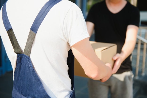 Servizio di fattorino con scatole in mano davanti alle porte di casa del cliente