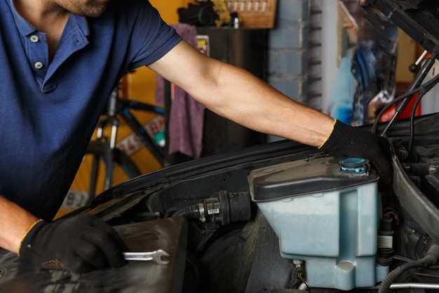 Servizio di riparazione auto manutenzione e concetto di persone meccanico auto alla ricerca di un malfunzionamento nel motore dell'auto