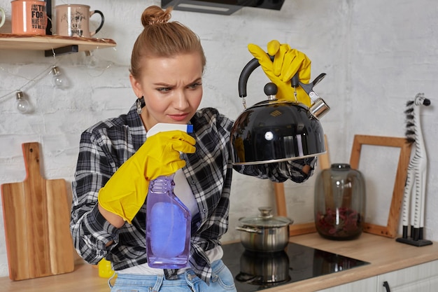 Servizio domestico e concetto di pulizia signora bionda felice che pulisce bollitore da cucina