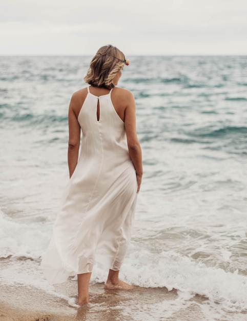 Servizio fotografico di una donna incinta che cammina sulla spiaggia