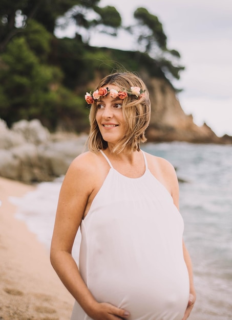 Servizio fotografico di una donna incinta che cammina sulla spiaggia