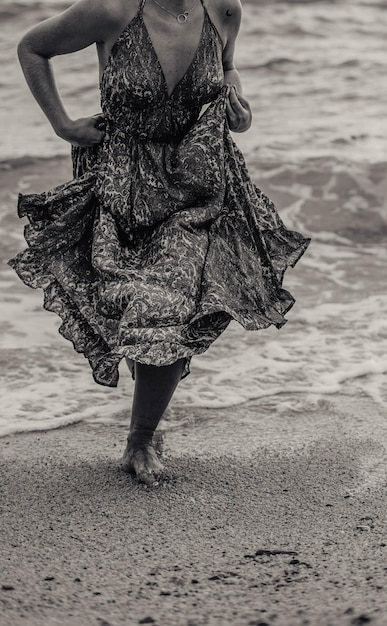 Servizio fotografico di una donna incinta che cammina sulla spiaggia