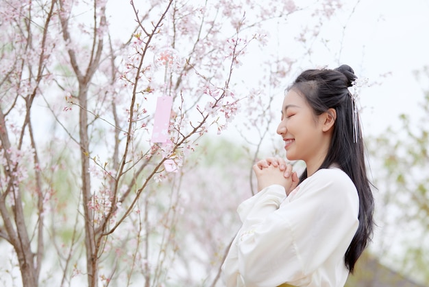 Servizio fotografico Modello femminile asiatico con bellissimi fiori di ciliegio sullo sfondo della natura