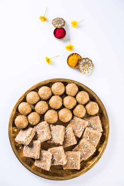 Sesamo o ril gul o Tilgul laddu con haldi kumkum con fiori per il festival di Makar Sankranti, messa a fuoco selettiva