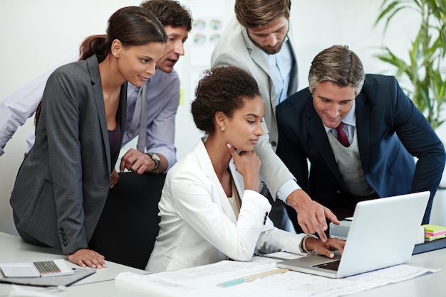 Sessione di strategia del team in corso Foto di un gruppo di uomini d'affari che lavorano insieme su un laptop