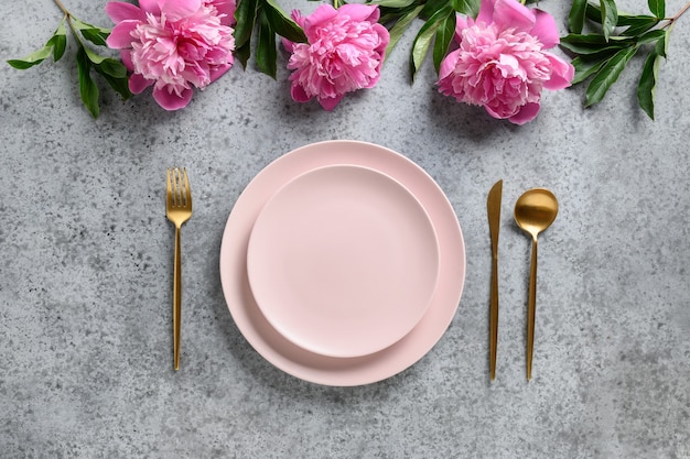 Set da tavola Elegance con piatto rosa decorato con fiori di peonia.