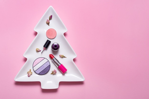 Set di accessori per il trucco sull'albero di Natale, copia spazio, sfondo rosso