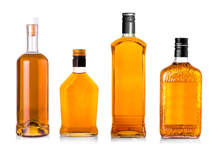Foto set di belle bottiglie di whisky su sfondo ben illuminato.