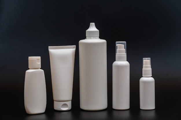 Set di bottiglie di plastica bianche per confezioni di tubi su sfondo nero Per prodotti cosmetici Per flaconi di crema con lozione di olio spray o gel o sapone per shampoo