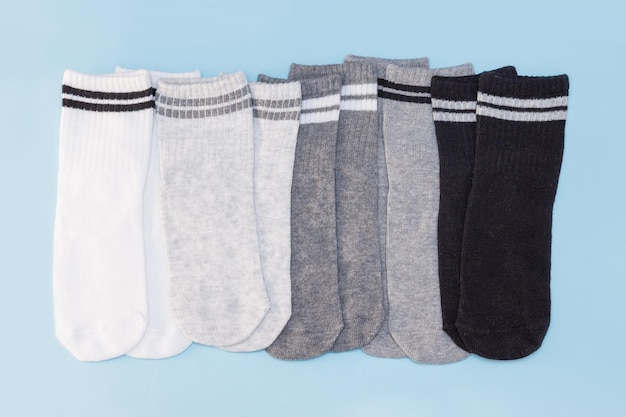 Set di calzini corti a righe bianche, grigie, nere su fondo blu.