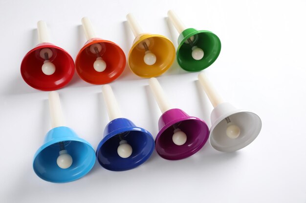 Set di campanelli a mano in metallo brillante su sfondo bianco Giocattolo musicale Montessori