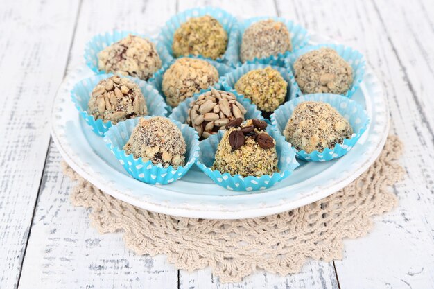 Set di caramelle al cioccolato, sul piatto, su fondo di legno