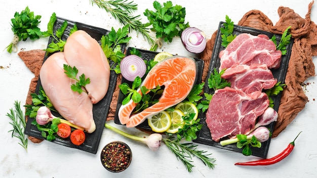 Set di carne cruda Maiale e pesce di vitello Vista dall'alto su uno sfondo di legno bianco Spazio libero per il testo