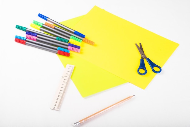 Set di carte a colori, righello, forbici, pennarelli e matita per lavori creativi su sfondo bianco Vista dall'alto Progetti artigianali di carta flatlay