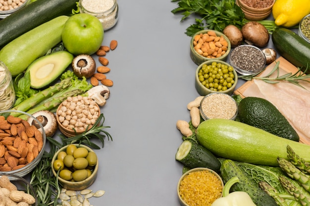 Set di cibo equilibrato, verdure verdi, semi di noci, carne di pollo su sfondo grigio