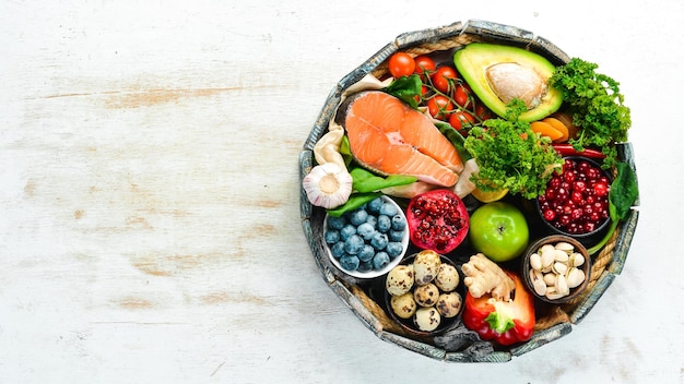 Set di cibo sano in una scatola di legno verdure frutta pesce carne noci ed erbe aromatiche Vista dall'alto Spazio libero per la copia